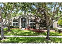 Charming home featuring a manicured lawn, mature trees, and a welcoming front entrance at 806 Spring Island Way, Orlando, FL 32828
