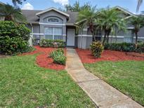 Charming townhome with a well-manicured front yard, landscaped with colorful plants and mulch, leading to the front door at 13546 Summerton Dr, Orlando, FL 32824