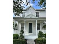 Charming home featuring a covered front porch with ceiling fans and neatly manicured landscaping at 14147 Mailer Blvd, Orlando, FL 32828