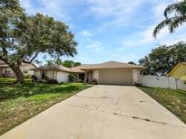 Charming single-story home featuring a well-manicured lawn, mature trees, and a two-car garage at 1818 Portview Ave, Deltona, FL 32738