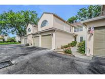 Exterior view of a townhouse showcasing the attached garage and neutral color palette at 3030 Clubview Dr # Ge, Orlando, FL 32822