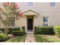Charming townhome entrance with manicured landscaping and a welcoming front door at 3537 Seneca Club Loop # B, Orlando, FL 32808