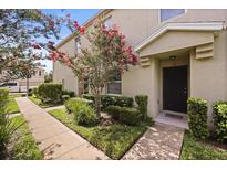 Inviting exterior of a townhome featuring a well-manicured lawn and a charming tree in the front yard at 3537 Seneca Club Loop # B, Orlando, FL 32808