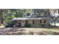 Charming single-story home with a covered parking area and well-maintained landscaping in a beautiful shady setting at 401 Sunny Ct, Fruitland Park, FL 34731