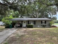 Charming single-story home featuring a covered carport, a welcoming front door, and a well-maintained lawn at 401 Sunny Ct, Fruitland Park, FL 34731