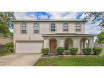 Two-story home with a charming arched porch, attached garage, manicured lawn and mature landscaping at 4531 Se 30Th St, Ocala, FL 34480