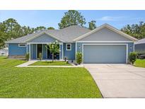Charming, single-story home with a manicured lawn, attached garage, and a welcoming front porch at 5531 Marys Villa Rd, Groveland, FL 34736