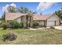 Charming single-story home with brick accents and mature landscaping in a quiet residential neighborhood at 6970 Knightswood Dr, Orlando, FL 32818