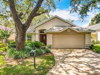 Charming single-story home featuring a brick driveway, well-maintained landscaping and an attached two-car garage at 748 Andover Cir, Winter Springs, FL 32708