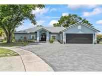 Beautiful single-story home featuring a gray brick driveway and a well-manicured lawn at 8248 Marbella View Ct, Orlando, FL 32817