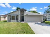 Charming single-story home featuring a well-manicured lawn and a two-car garage at 826 Long Bay Ct, Kissimmee, FL 34741