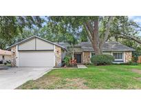 Charming single-story home featuring stone accents, a well-manicured lawn, and a two-car garage at 8308 Granada Blvd, Orlando, FL 32836