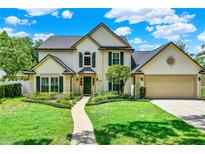 Charming two-story home featuring a well-manicured lawn, lush landscaping, and an inviting walkway to the front door at 991 Hawthorne Cove Ct, Ocoee, FL 34761