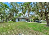 Charming single-story home with a well-maintained lawn, mature trees, and a welcoming front porch at 1000 Sal St, Ocoee, FL 34761
