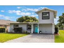 Charming home featuring a two-story accent, gray paint and a vibrant blue front door at 1615 W Gadsen Blvd, Orlando, FL 32812