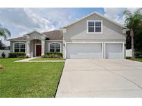 Charming home featuring a well-manicured lawn and a two-car garage at 1637 Mistflower Ln, Winter Garden, FL 34787
