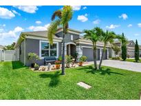 Charming single-story home with lush green lawn, grey exterior, stone driveway, and curb appeal at 2319 Dammar St, Orlando, FL 32824
