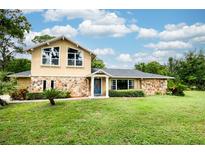 Charming two-story home with stone accents, beautiful landscaping, and a well-maintained lawn at 3102 Cecelia Dr, Apopka, FL 32703