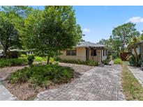 Charming home featuring a stone-paved driveway, lush landscaping, and a welcoming entrance at 3223 N Orange Ave, Orlando, FL 32803