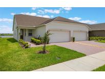 Charming home featuring a well manicured lawn, lush landscaping, and a convenient two-car garage at 3240 Canna Lily Pl, Clermont, FL 34711