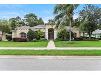 Charming single-story home with a well-manicured lawn and mature trees, and tan exterior at 343 Leslie Ln, Lake Mary, FL 32746