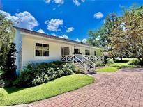 Charming home featuring a brick pathway, white siding, and a quaint front porch with decorative railing at 625 Woodlawn Cemetery Rd, Gotha, FL 34734