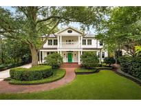 Charming two-story home with a welcoming front porch, manicured landscaping, and a vibrant green front door at 1011 Lake Davis Dr, Orlando, FL 32806