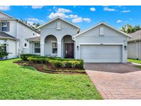 Charming single-Gathering home with a well-manicured lawn, brick driveway, and inviting curb appeal at 1061 Castlevecchio Loop, Orlando, FL 32825