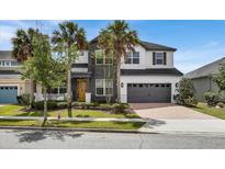 Beautiful two-story home with gray and white exterior, yellow door, attached garage, and well-maintained landscaping at 10640 Tibbett St, Orlando, FL 32832