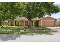 Charming single-story home featuring a well-maintained lawn, mature shade tree, and attached two-car garage at 119 Glendale Dr, Longwood, FL 32750