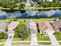 An aerial view of a home with a beautiful pond view and lush landscaping in a desirable neighborhood at 1252 Ballyshannon Pkwy, Orlando, FL 32828