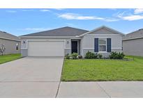 Charming single-story home featuring a two-car garage and a well-maintained lawn at 232 Summerlin Loop, Haines City, FL 33844