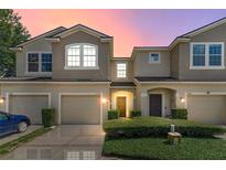 Townhouse exterior features a two-story design with attached garages and manicured landscaping at 232 Windflower Way, Oviedo, FL 32765