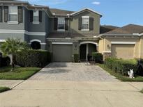 Charming townhome featuring a brick driveway, attached garage, and well-maintained landscaping at 2564 River Landing Dr, Sanford, FL 32771
