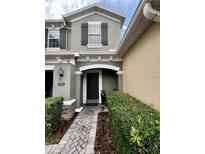 Inviting front entrance with a dark door, decorative stone accents, and a manicured garden bed at 2564 River Landing Dr, Sanford, FL 32771