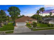 Charming single-Gathering home featuring a well-manicured lawn, mature trees and landscaping, and a two-car garage at 3713 Ocita Dr, Orlando, FL 32837