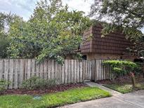 Charming townhome featuring a beautiful wooded exterior behind a fence and lush landscaping at 5302 Bamboo Ct # 447, Orlando, FL 32811