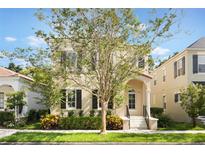 Charming two-story home with neutral-colored siding, complemented by a beautifully landscaped front yard and mature tree at 5350 Penway Dr, Orlando, FL 32814