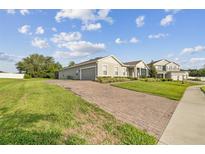 Beautiful home with brick driveway and well-maintained landscaping and large green yard at 730 Rominger Loop, Apopka, FL 32712