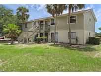 Two-story townhouse with exterior stairs and grassy front yard at 7344 Swallow Run # 7344, Winter Park, FL 32792