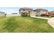 Two-story home featuring a spacious front lawn and well-manicured landscaping at 7603 Taormina Way, Clermont, FL 34714
