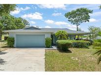 Charming single-story home with a well-maintained lawn, mature trees, and an attached two-car garage at 945 Shawna Shrs, Haines City, FL 33844