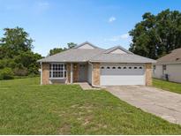 Charming single-story home with brick accents, well-manicured lawn, and attached two car garage at 10708 Brice Ct, Orlando, FL 32817