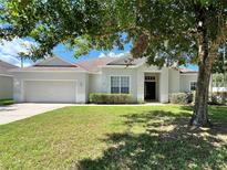 Charming single-story home featuring a well-manicured lawn and attached two-car garage at 109 Belgian Way, Sanford, FL 32773