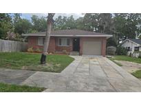 Charming brick home featuring an attached garage and a well-kept front yard with mature landscaping at 1205 Deleon Ave, Leesburg, FL 34748