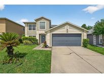 Charming two-story home featuring well-manicured lawn and a gray two-car garage door at 1224 Blackwater Pond Dr, Orlando, FL 32828