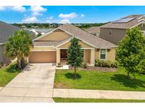 Charming single-story home with a well-manicured lawn, lush landscaping and attached two car garage at 1593 Osprey View Dr, Apopka, FL 32703