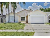 Charming single-story home with a two-car garage and well-maintained exterior, complemented by palm trees at 2742 Woodruff Dr, Orlando, FL 32837