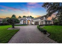 Stunning exterior view of luxury home showcasing the beautiful brick driveway and meticulous landscaping at 3316 Regal Crest Dr, Longwood, FL 32779