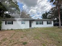 Charming single-Gathering home featuring a classic white facade, black door, and a green lawn at 4732 Luce Rd, Lakeland, FL 33813